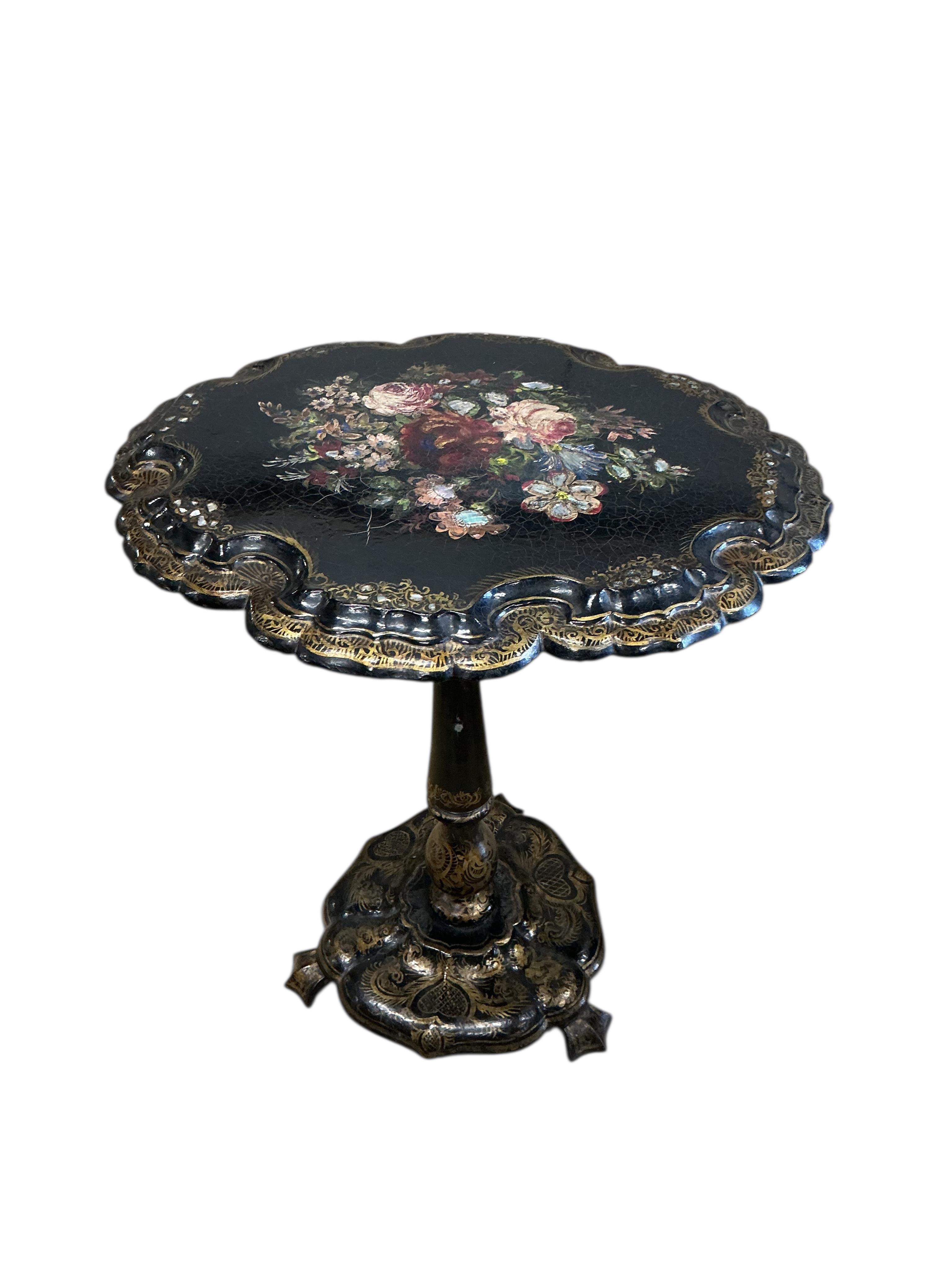 A Victorian mother of pearl inlaid papier-mâché oval tilt top wine table, width 58cm, height 67cm, and a similar cane seat chair